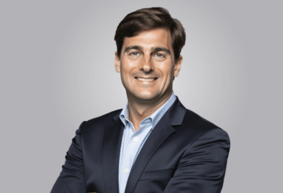 photo of a man in a blue jacket looking at the camera and smiling